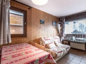 een slaapkamer met een bed, een bank en een raam bij Appartement La Clusaz, 2 pièces, 4 personnes - FR-1-304-81 in La Clusaz