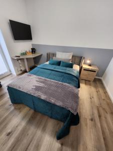 um quarto com uma cama com lençóis azuis e uma secretária em Balcony II Appartement em Bad Salzuflen