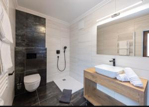 ein Bad mit einem Waschbecken, einem WC und einer Dusche in der Unterkunft Hotel Austria - inklusive Joker Card im Sommer in Saalbach-Hinterglemm