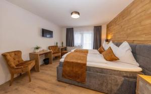 une chambre d'hôtel avec un lit et un canapé dans l'établissement Hotel Austria - inklusive Joker Card im Sommer, à Saalbach-Hinterglemm
