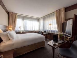 una camera d'albergo con un grande letto e una TV di Sofitel Lyon Bellecour a Lione