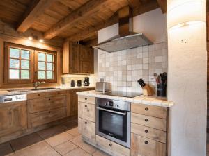 a kitchen with wooden cabinets and a stove top oven at Chalet pour 8 avec cheminée, proche des pistes, WiFi, garage, non fumeur - FR-1-304-110 in La Clusaz +15 photos