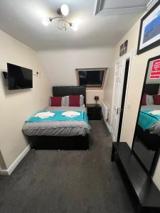 a bedroom with two beds and a flat screen tv at ABBEY HOLIDAY ACCOMMODATiON in Whitby