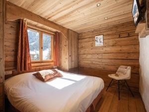 a bedroom with a bed in a log cabin at Appartement La Clusaz, 4 pièces, 7 personnes - FR-1-304-232 in La Clusaz