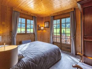 a bedroom with a bed in a room with windows at Chalet La Clusaz, 5 pièces, 8 personnes - FR-1-304-243 in La Clusaz