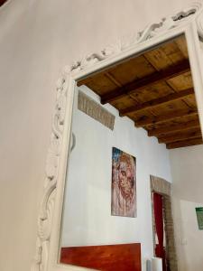 uno specchio in una stanza con un dipinto sul muro di Green Rooms Ferrara a Ferrara
