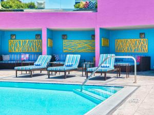 a pool with chairs and tables next to a building at Hotel Sofitel Los Angeles at Beverly Hills in Los Angeles