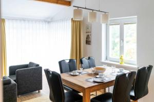 ein Esszimmer mit einem Holztisch und schwarzen Stühlen in der Unterkunft Ferienwohnung "Bernstein" im Ostsee-Domizil Sandburg in Kühlungsborn + 9 Fotos