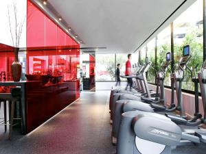 a gym with a row of treadmills and machines at Hotel Sofitel Los Angeles at Beverly Hills in Los Angeles
