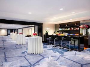 a hotel lobby with tables and a bar at Hotel Sofitel Los Angeles at Beverly Hills in Los Angeles