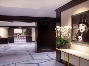 a lobby with a portrait of a woman and flowers at Hotel Sofitel Los Angeles at Beverly Hills in Los Angeles
