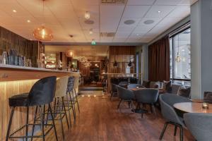 un bar con sillas y mesas en un restaurante en Best Western Plus Grand Hotel Elektra en Ludvika