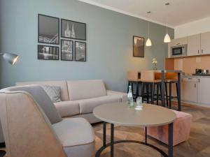 - un salon avec un canapé et une table dans l'établissement Mercure Hotel Koeln Belfortstrasse, à Cologne