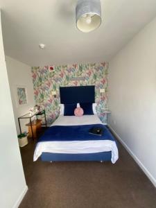 1 dormitorio con 1 cama con colcha azul en Gordons, en Cheddar