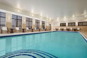 een zwembad in een hotel met stoelen en tafels bij Homewood Suites by Hilton Denver - Littleton in Littleton