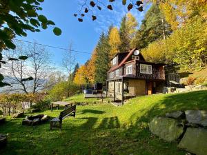 a house on a hill with a bench in the grass at Chaloupka na stráni in Ostravice