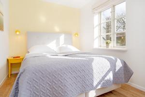 ein weißes Schlafzimmer mit einem Bett und einem Fenster in der Unterkunft Michel in Dahme