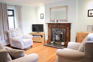 a living room with a fireplace and a tv at The Coach Inn in Strabane