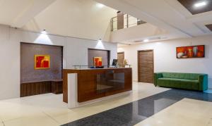a lobby with a reception desk and a green couch at Treebo Trend Eco Stay T Nagar in Chennai
