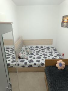 a small bedroom with a bed and a mirror at Apartments TOMISIVO Ohrid Kaj CICO in Ohrid