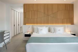 a bedroom with a large white bed with white pillows at Royal Hideaway Corales Suites in Adeje