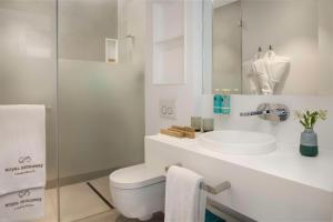 a white bathroom with a toilet and a sink at Royal Hideaway Corales Suites in Adeje
