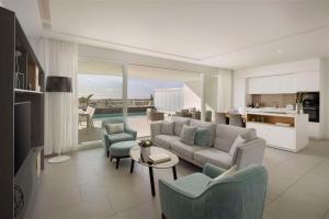 a living room with a couch and chairs and a table at Royal Hideaway Corales Suites in Adeje
