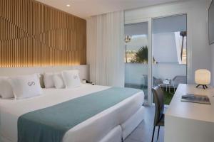 a hotel room with a large bed and a desk at Royal Hideaway Corales Suites in Adeje