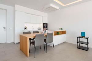 a kitchen with a wooden table and chairs at Royal Hideaway Corales Suites in Adeje