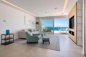 a living room with a couch and a tv at Royal Hideaway Corales Suites in Adeje
