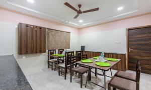 a dining room with tables and chairs and a ceiling fan at Treebo Trend Eco Stay T Nagar in Chennai