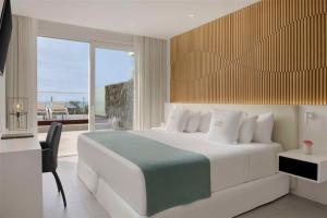 a bedroom with a white bed with a view of the ocean at Royal Hideaway Corales Suites in Adeje