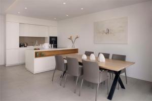 a kitchen with a dining room table and chairs at Royal Hideaway Corales Suites in Adeje