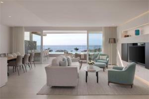 a living room with couches and chairs and a television at Royal Hideaway Corales Suites in Adeje