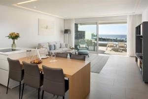 a kitchen and living room with a table and chairs at Royal Hideaway Corales Suites in Adeje
