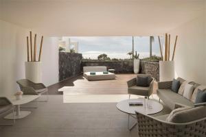 a living room with a couch and chairs and tables at Royal Hideaway Corales Suites in Adeje