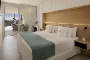 a bedroom with a large white bed and a balcony at Royal Hideaway Corales Suites in Adeje