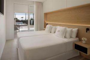 a bedroom with a large white bed and a balcony at Royal Hideaway Corales Suites in Adeje