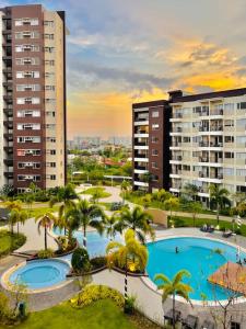 a view of two pools and palm trees and buildings at * *K2 Nordic Haven in Iloilo City