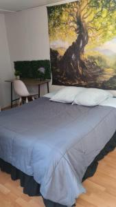 1 dormitorio con 1 cama con una pintura en la pared en valle, en Copiapó