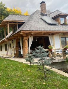 une maison avec un panneau solaire sur le toit dans l'établissement Casa cu șindrilă, à Vălenii de Munte