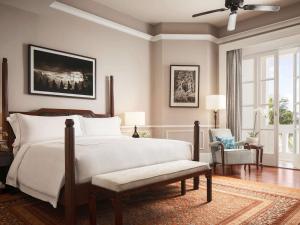 Raffles Grand Hotel d'Angkor tesisinde bir odada yatak veya yataklar