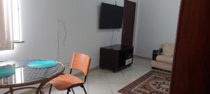 a dining room with a table and chairs and a television at Apartamento completo e bem localizado in Vitória da Conquista
