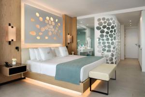 1 dormitorio con 1 cama blanca grande y baño en Royal Hideaway Corales Beach - Adults Only, en Adeje