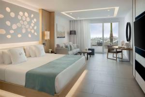 a hotel room with a bed and a living room at Royal Hideaway Corales Beach - Adults Only in Adeje