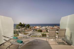 a balcony with chairs and a view of a city at Royal Hideaway Corales Beach - Adults Only in Adeje