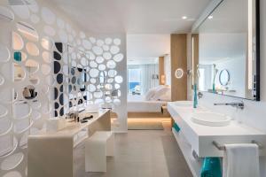 a bathroom with a sink and a toilet and a bed at Royal Hideaway Corales Beach - Adults Only in Adeje