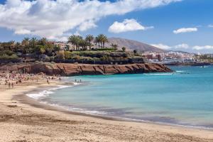 a beach with a group of people in the water at Royal Hideaway Corales Beach - Adults Only in Adeje