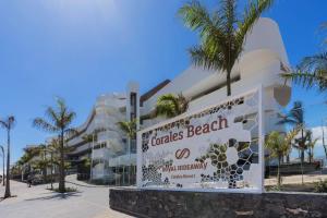 a sign in front of a building with palm trees at Royal Hideaway Corales Beach - Adults Only in Adeje