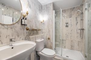 a bathroom with a sink toilet and a mirror at Crisol Mesón del Cid in Burgos